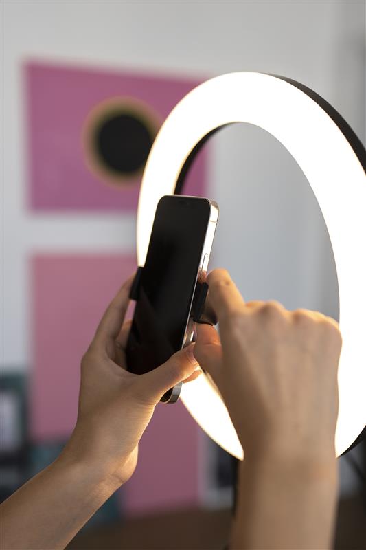 image of a person setting up their phone on a tripod with a ring light to record.jpg